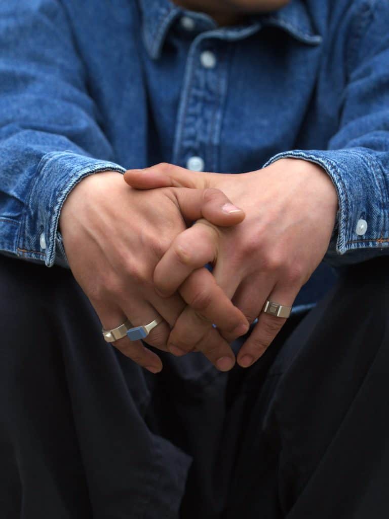 Close-up of hands wearing Studio GOGO rings, showing the mix of sculptural forms and casual, modern style.