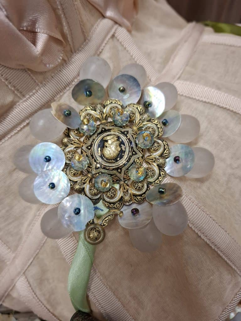 Close-up of a handcrafted floral brooch by Anton Femia, made with sequins, pearls, and layered materials. Courtesy of the designer, Anton Femia.