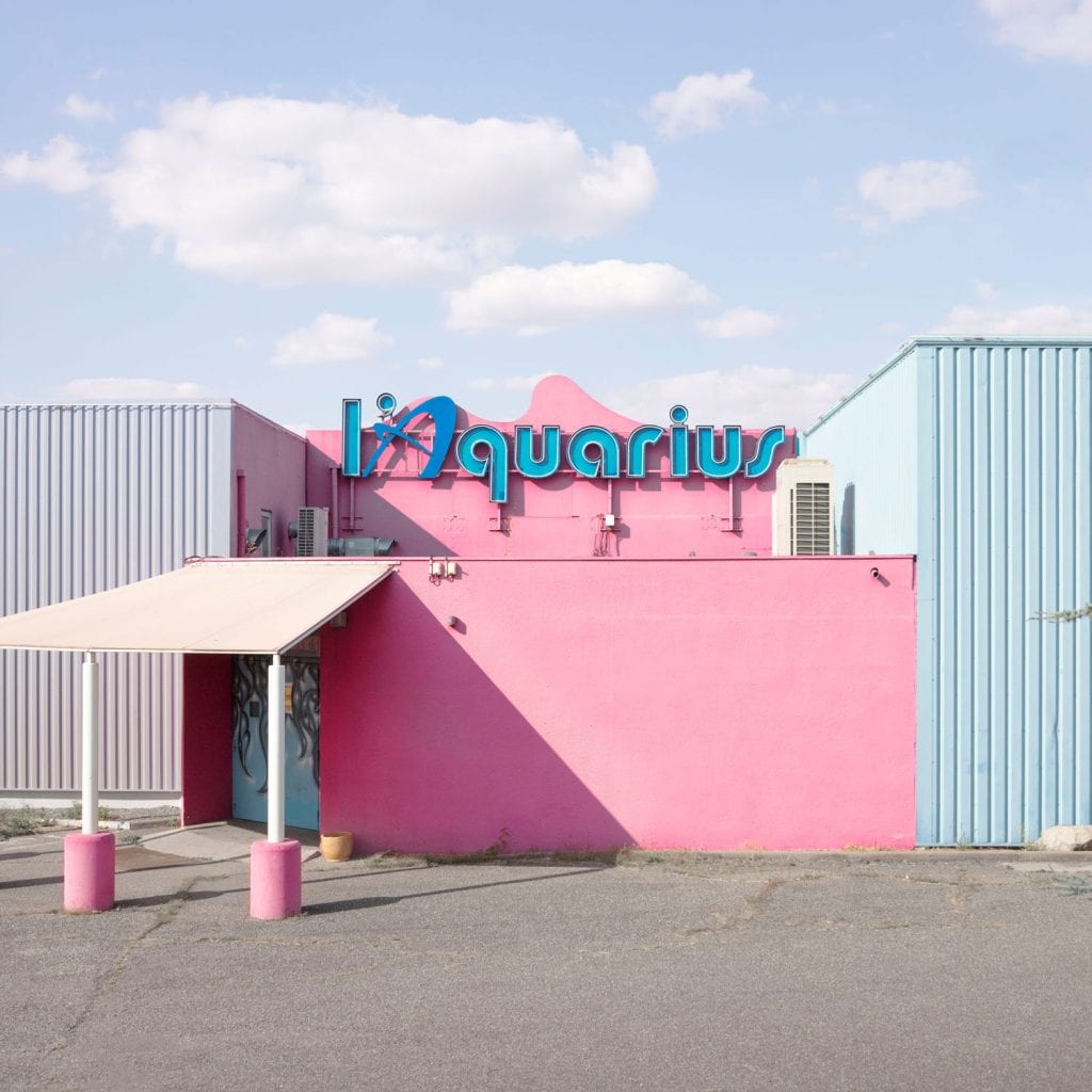 Facade of L’Aquarius nightclub in pink and blue, with a retro sign and no visible activity. FRANÇOIS PROST 