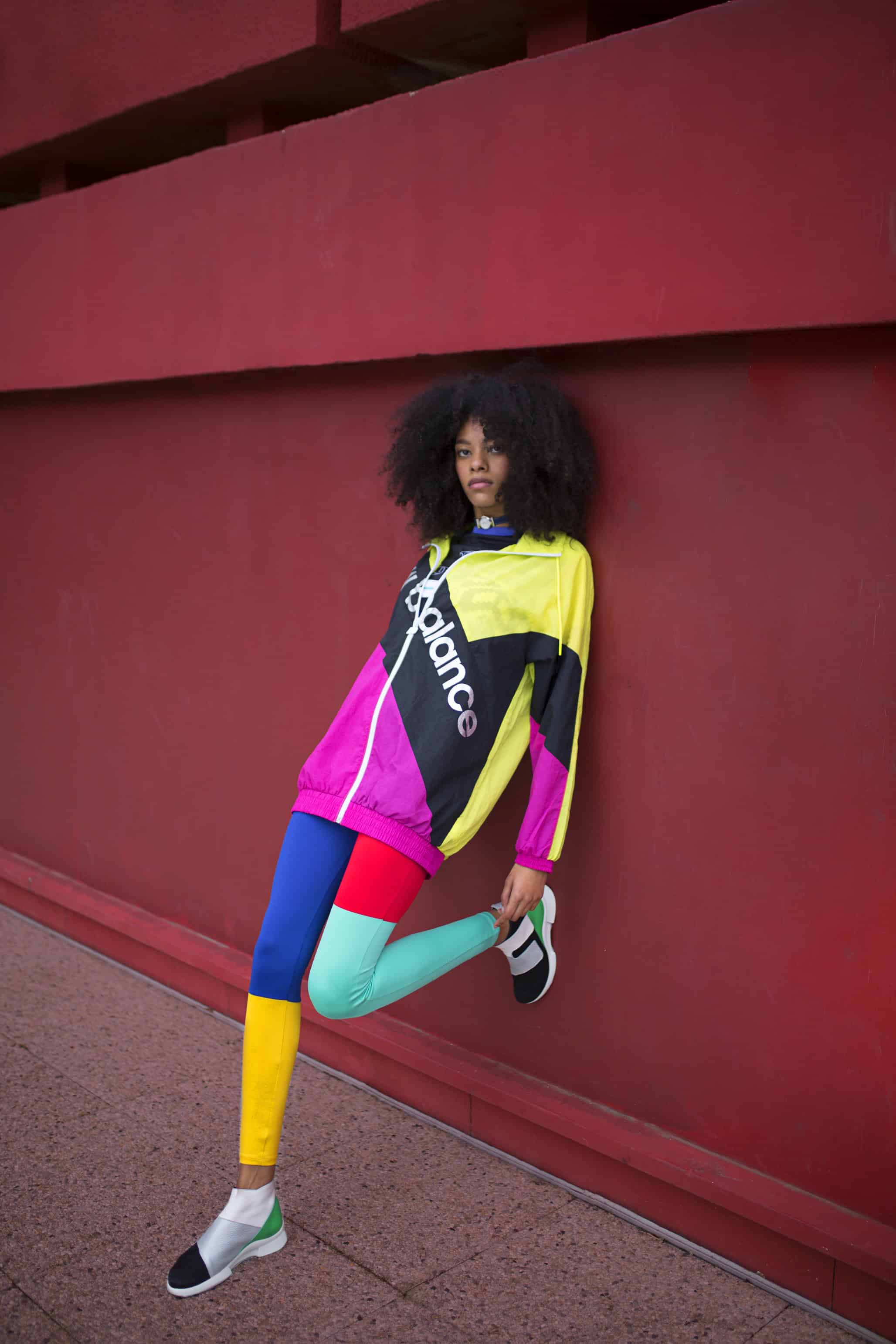 Sneakers ARCHE, denim strap watch worn around her neck MICHEL HERBELIN, crop top & black jogging pants ELLESSE, windbreaker NEW BALANCE.
