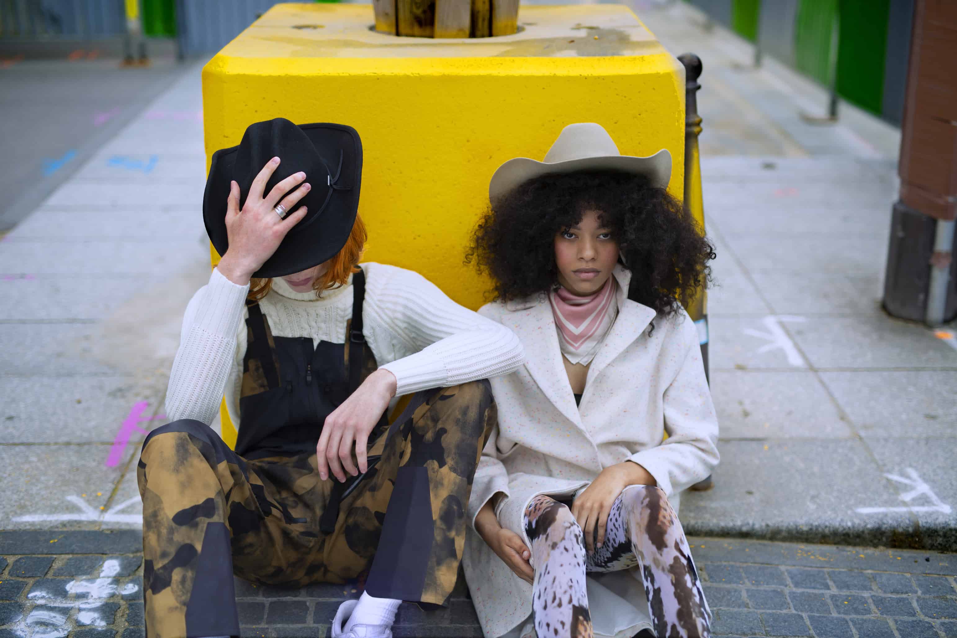 Him: Puffy jacket with exposed feathers CHEVIGNON, camouflage overalls THE North Face, White turtleneck NORTH SAILS, cowboy hat Stetson. Her: White coat MOLLY BRACKEN, Silk scarf GANT, serpent print tights WOLFORD, cowboy hat STETSON.