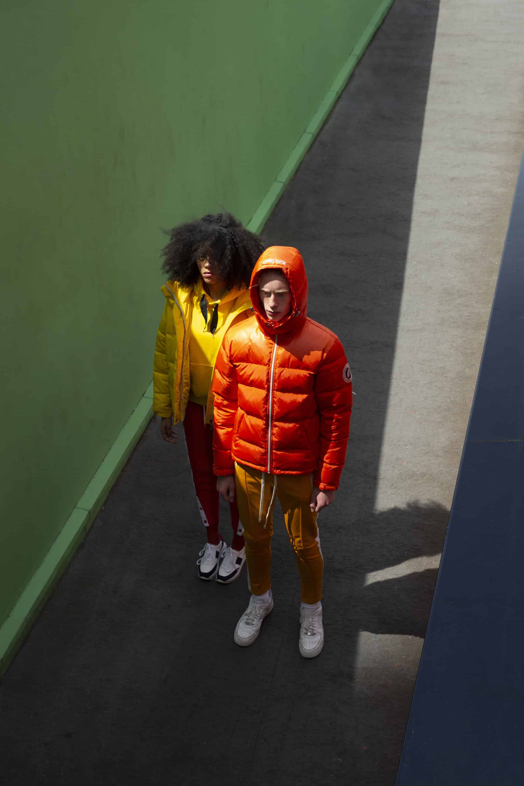 Her: White & navy shoes BORDEN, yellow sweatshirt & bright yellow puffy jacket LEE. Him: Mustard yellow vintage sweatpants & orange puffy jacket SWEET PANTS.