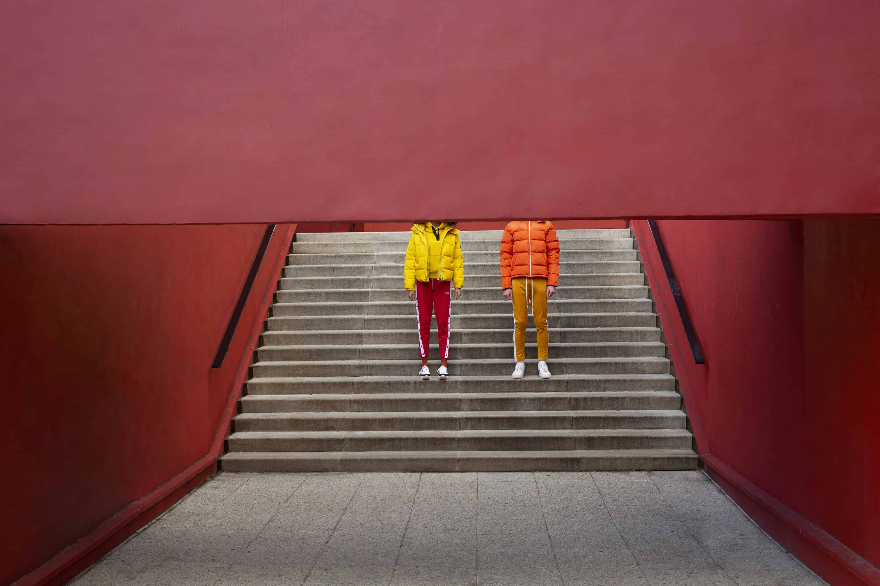 Her: White & navy shoes BORDEN, yellow sweatshirt & bright yellow puffy jacket LEE. Him: Mustard yellow vintage sweatpants & orange puffy jacket SWEET PANTS.