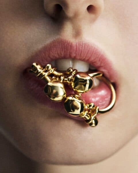 Close-up of lips with gold jewelry inspired by VIRASAAT JUMBO & MINI by Byredo.