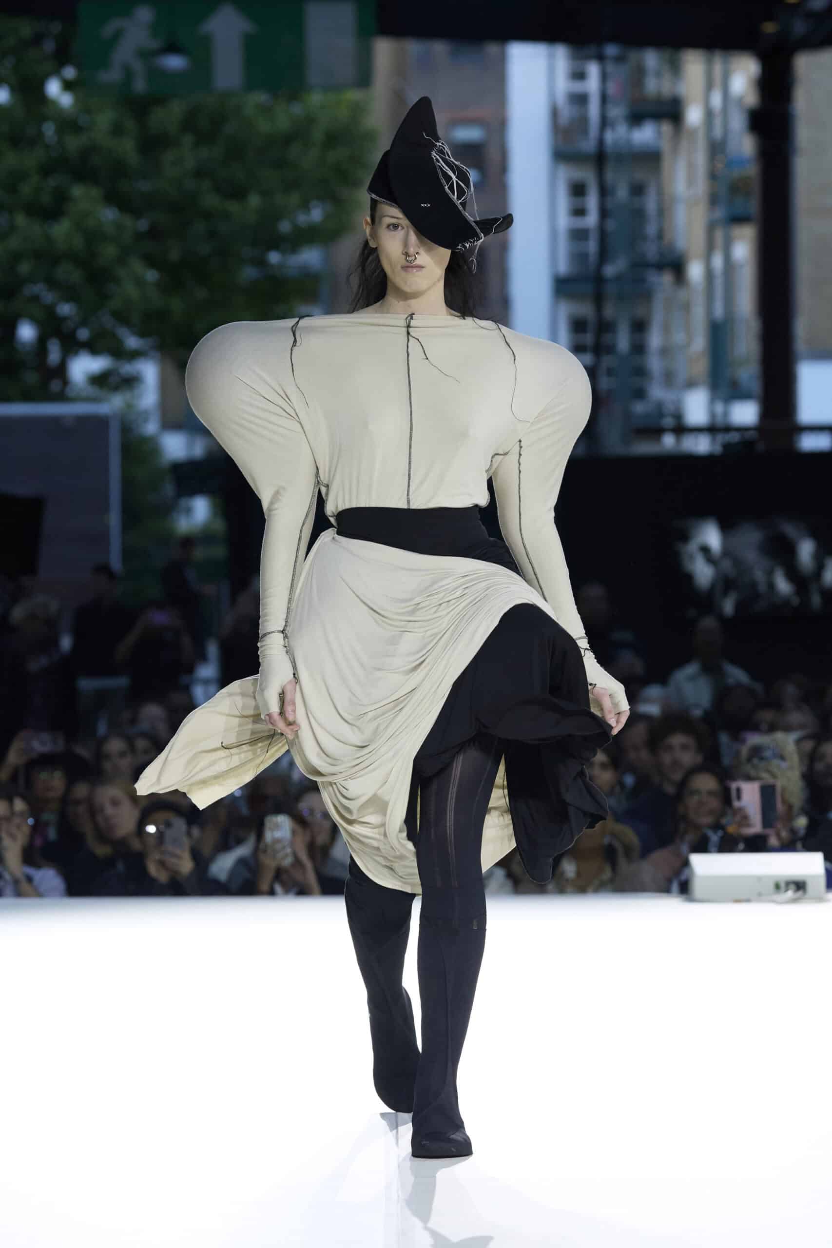 Alt: "Models present collections by emerging designers during the Fashion District Showcase 2026 in London, United Kingdom. The showcase featured work"