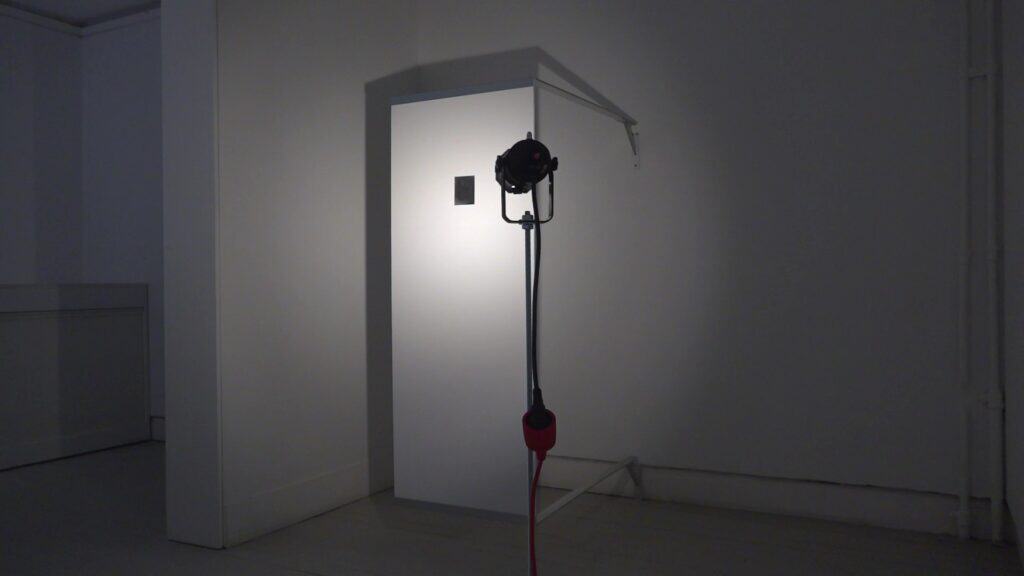 Installation view of self-portrait "In memory of my heart’s shape, which is the size of my hand" from 2026. A white rectangle extends from the wall to welcome visitors as they enter the exhibition.