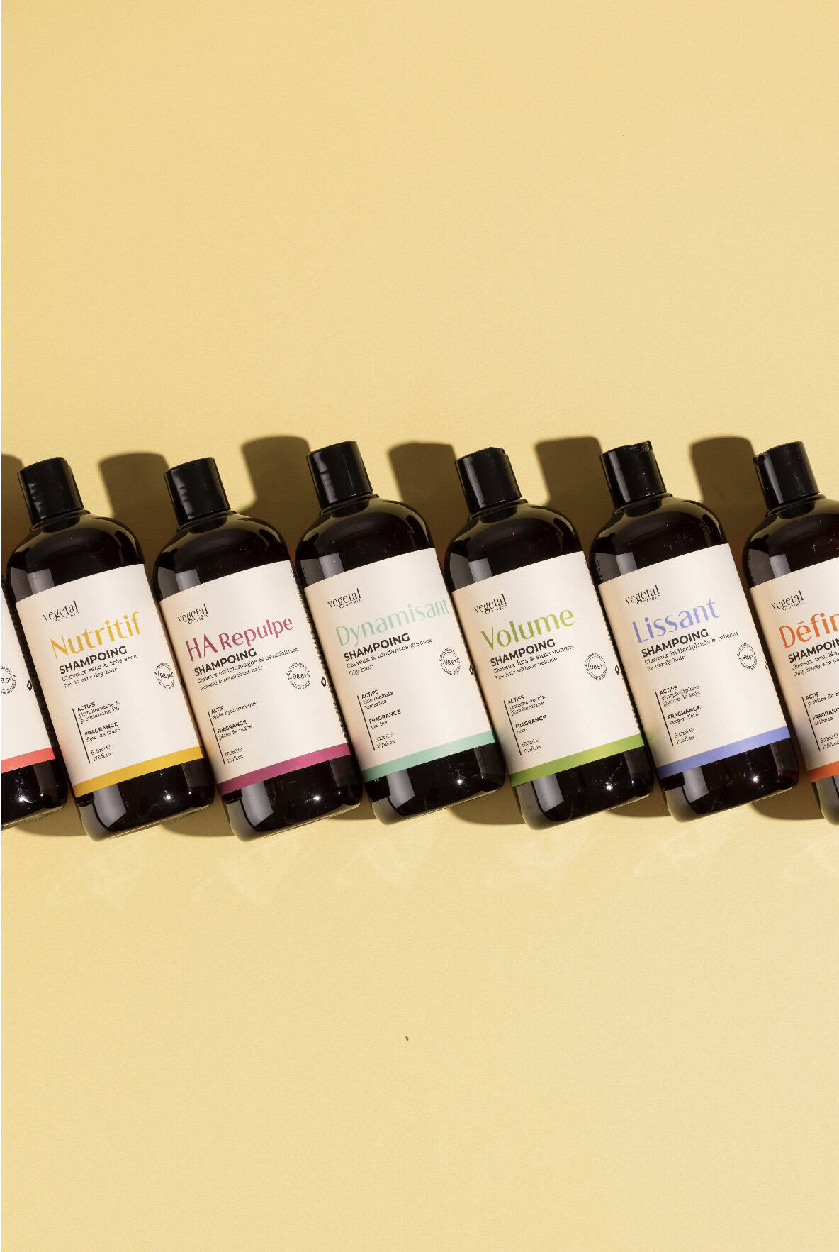 A lineup of Vegetal Origin haircare bottles displayed on a soft yellow background.