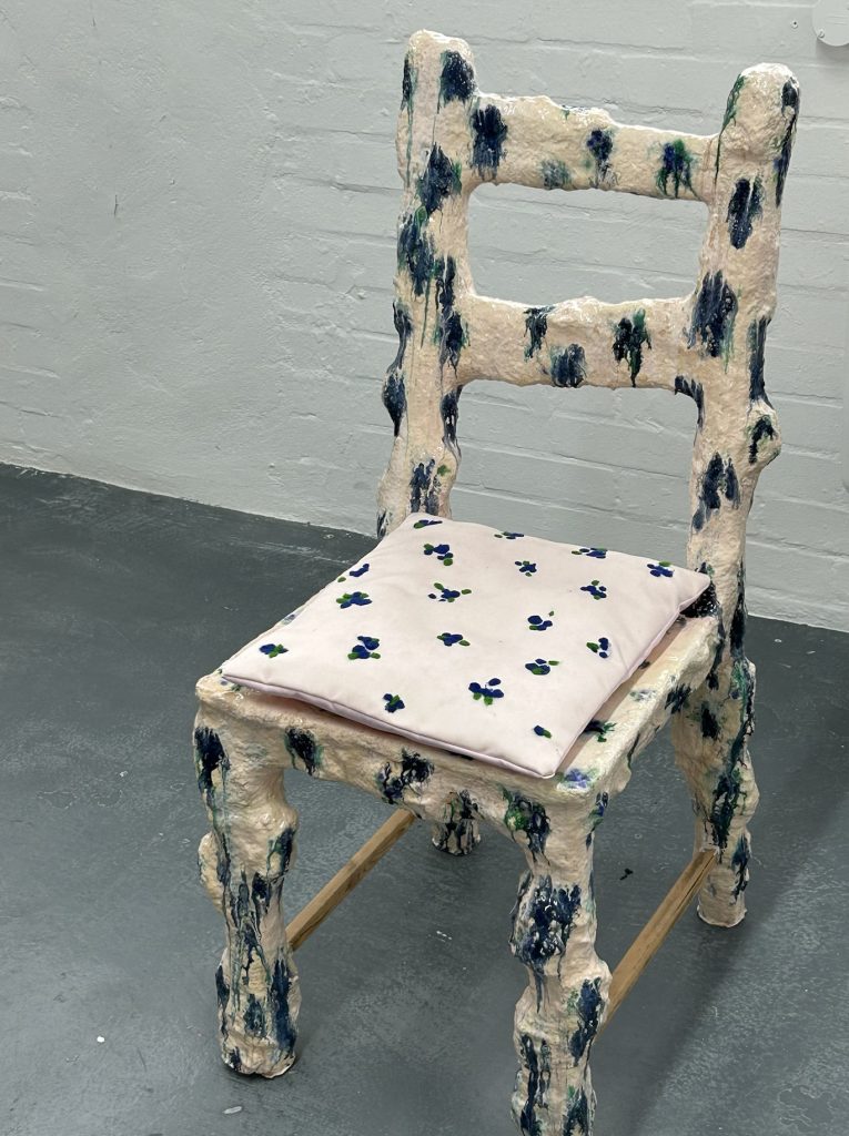 Paint-splattered sculptural chair on display at APOC store, illustrating the fusion of function and design.