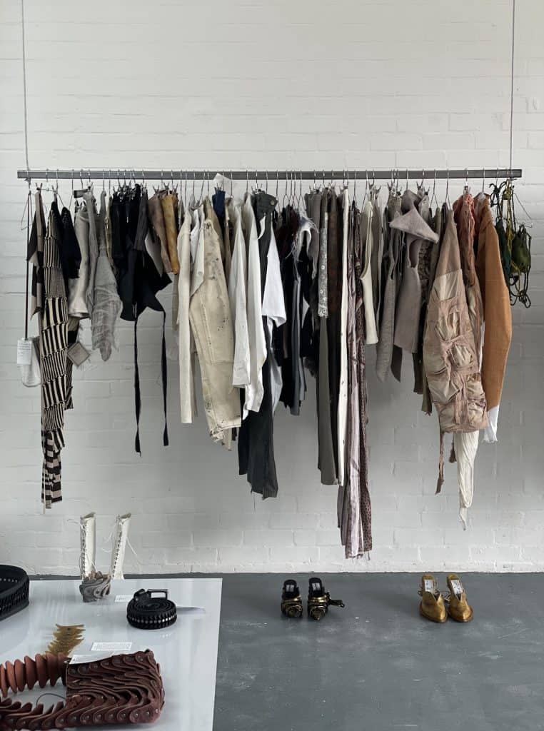 Close-up of designer boots and mixed-material seating at APOC store, merging fashion, furniture, and gallery aesthetics.