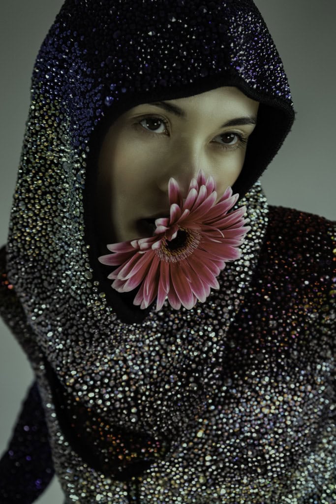 Circular image of woman with a flower in her mouth
