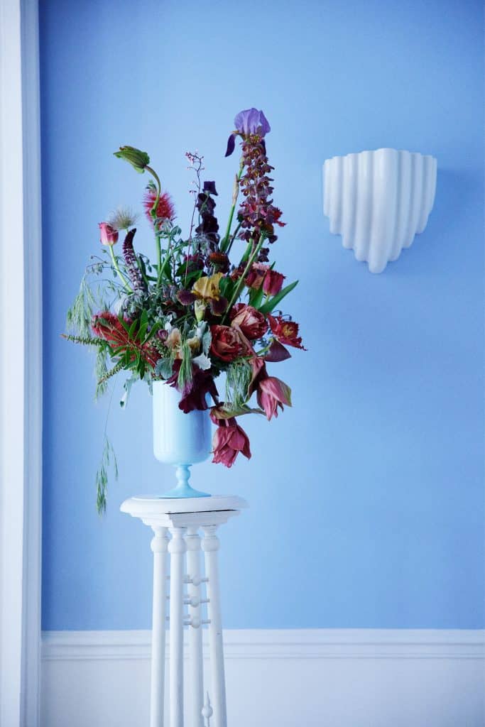 Chic floral bouquet by Debeaulieu Paris — vibrant color composition in a blue-lit setting