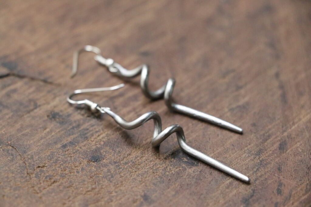 Silver anti-poaching earrings symbolizing wildlife conservation efforts.