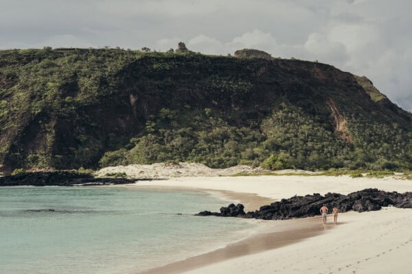 Galápagos Beach with cliffs and turquoise water, scenic coastal landscape.