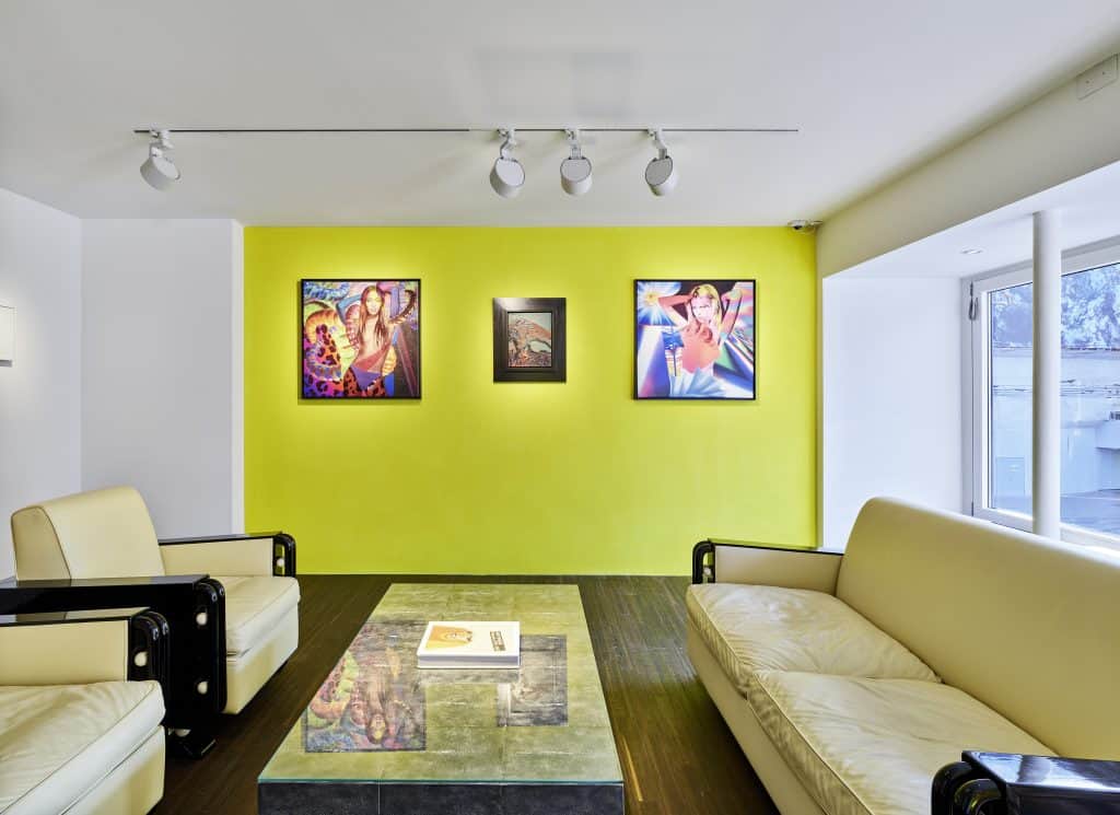 Lounge area within the Warhol/Cutrone exhibition, with couches and Pop art on the wall.