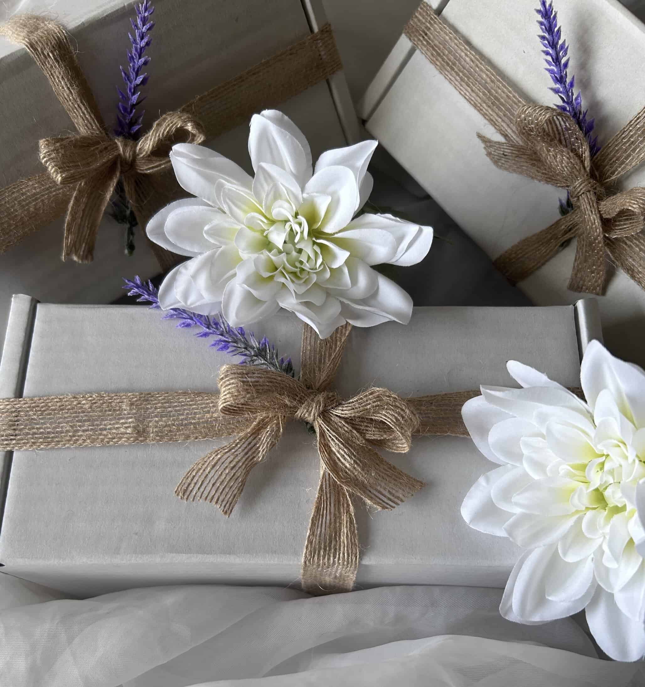 gift boxes tied with twine, decorated with white flowers and lavender sprigs. Courtesy of FHL Natural Products.