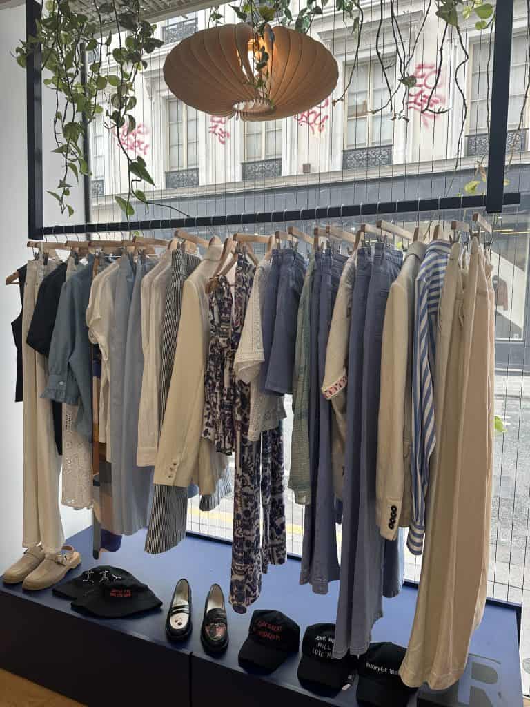 Clothing racks and curated fashion items inside Twins Concept Store in Paris, showcasing a modern and modular boutique layout.