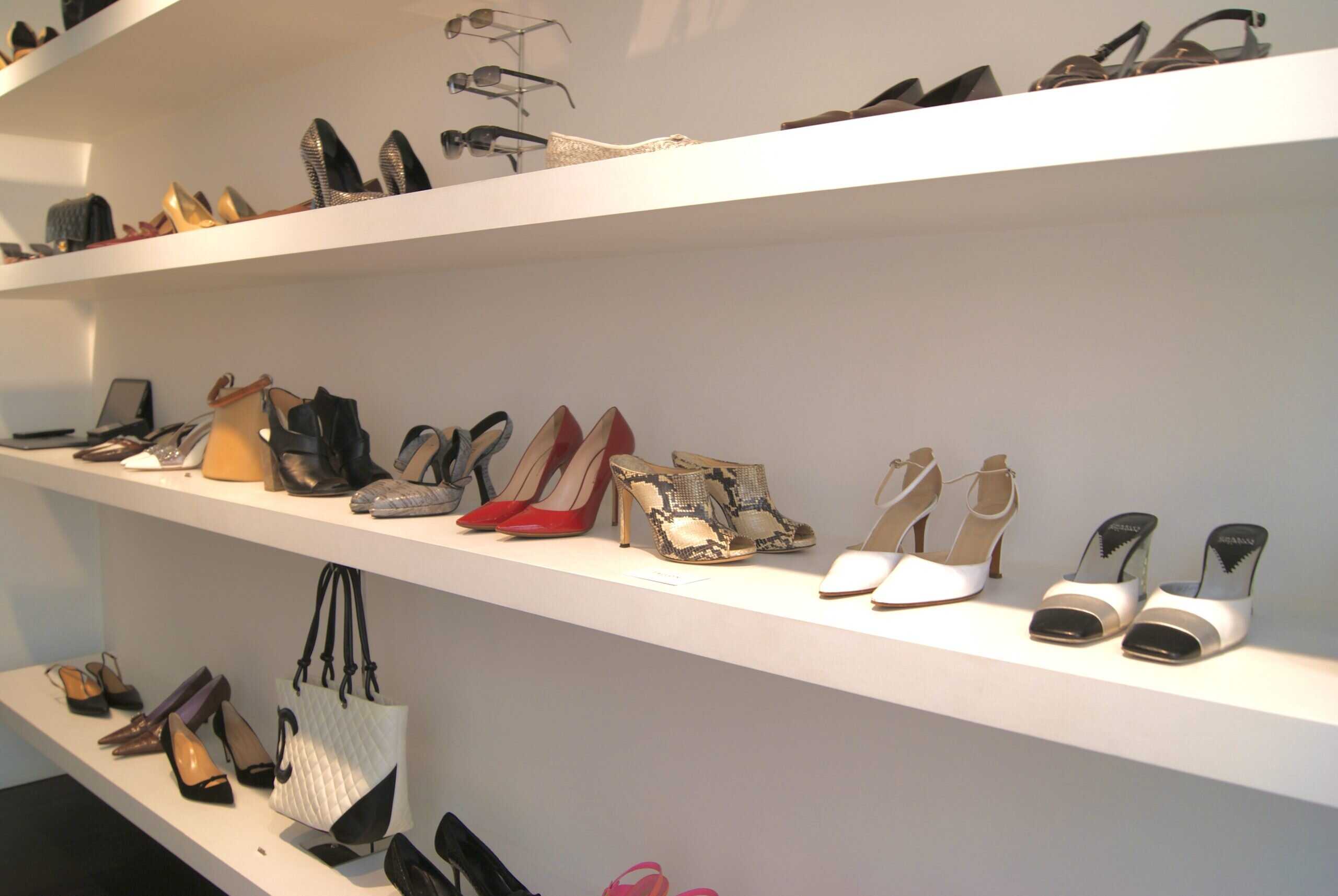 Wide wall-mounted shelves filled with assorted vintage designer heels in various colors and textures at Tallon Vintage.