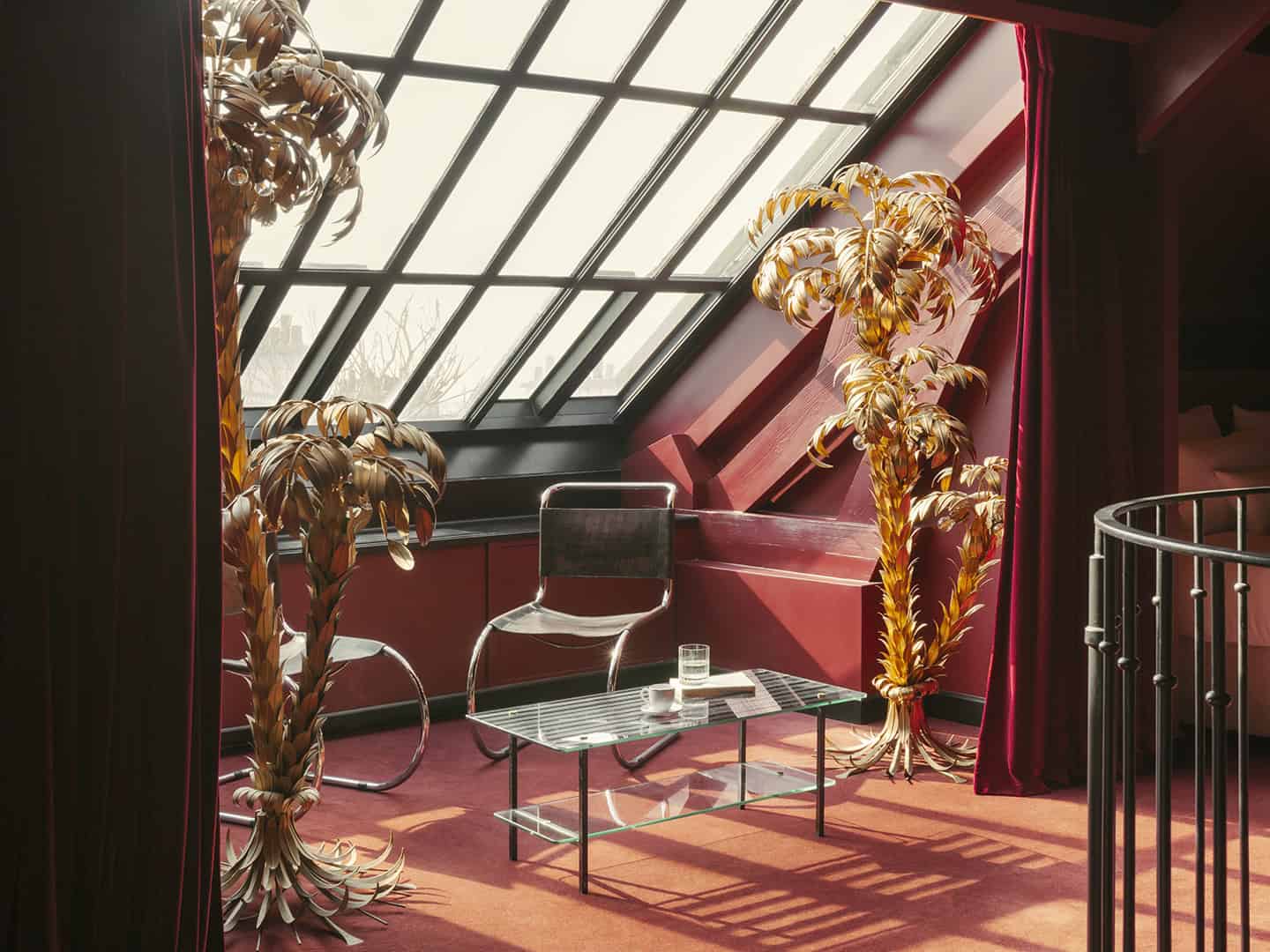 Hotel Particulier, Les Folies du Ciel suite in the rooftop. With golden palm trees, industrial window and red velvet from floor to ceiling 