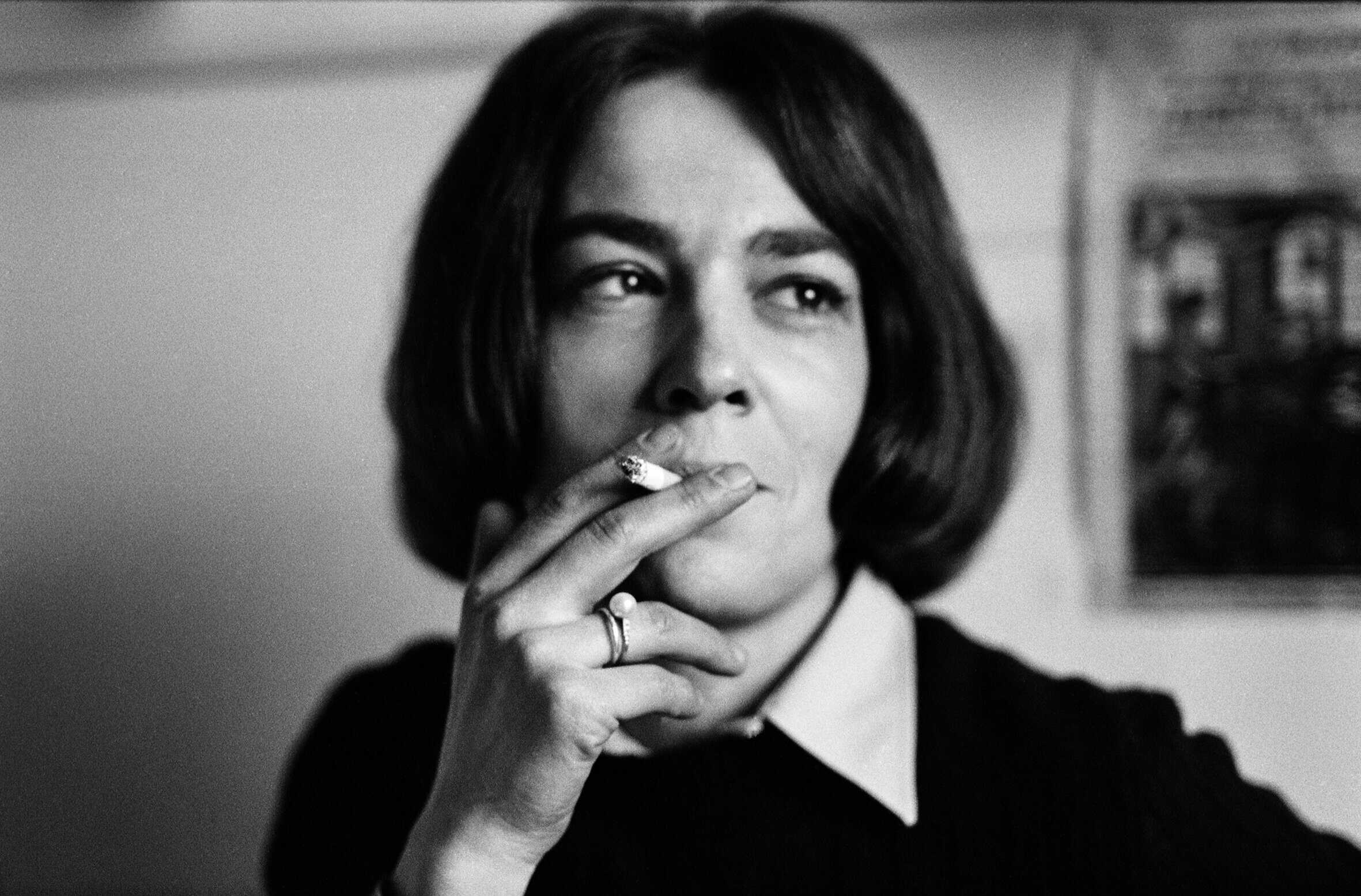 Black-and-white portrait of a Nicole Lala with a bob haircut, holding a cigarette near her lips and gazing thoughtfully to the side. Photo by Nicole Lala, courtesy of her daughter Delphine.