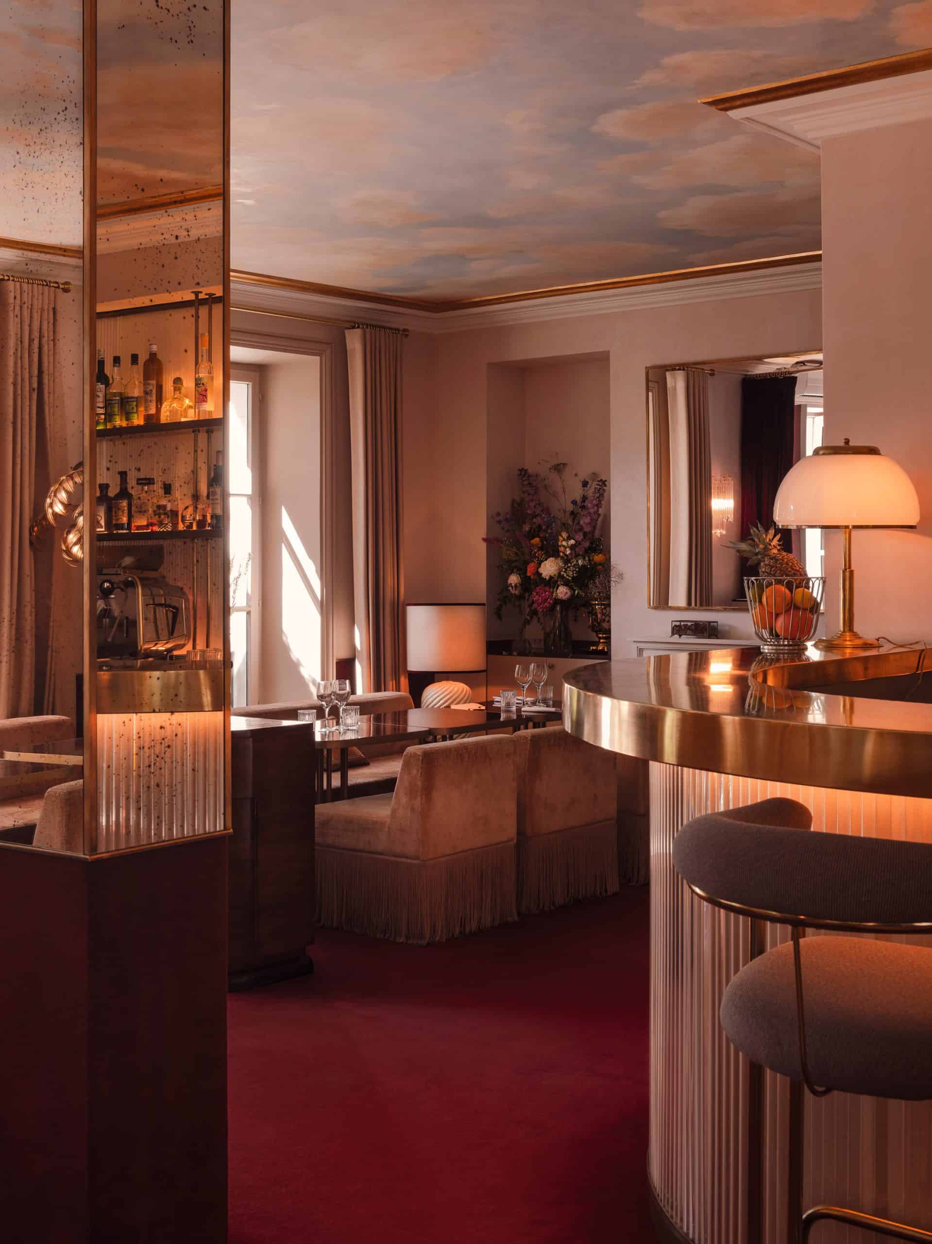 Interior view of Hôtel Particulier Montmartre featuring a mirrored bar, velvet seating, and warm ambient lighting.