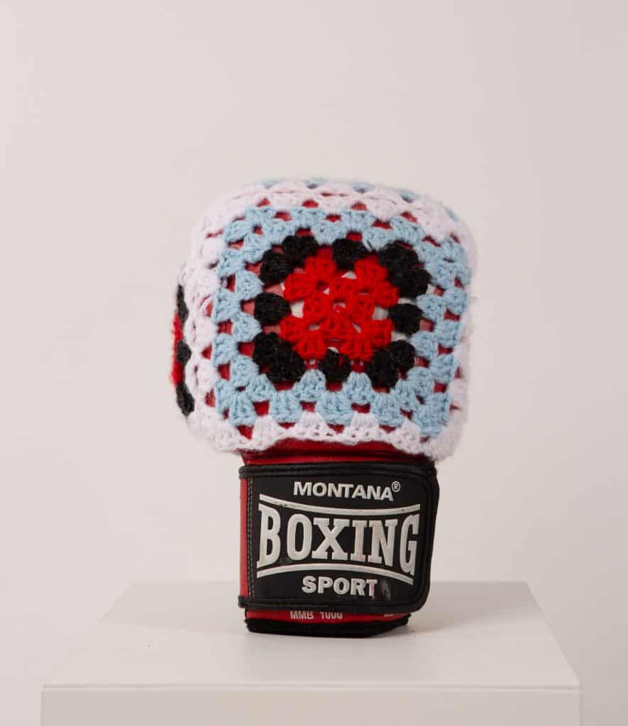 Vintage boxing glove covered in red, blue and white crochet squares, part of Sophie Inard’s sculptural series.
