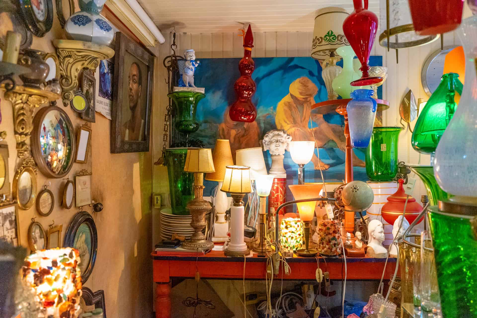 Interior shot of Verreglass filled with antique lamps, mirrors and glass artifacts.