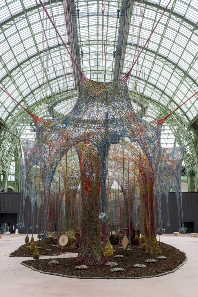 Wide view of Ernesto Neto’s Nosso Barco Tambor Terra, showing the full expanse of the woven canopy suspended inside the Grand Palais.