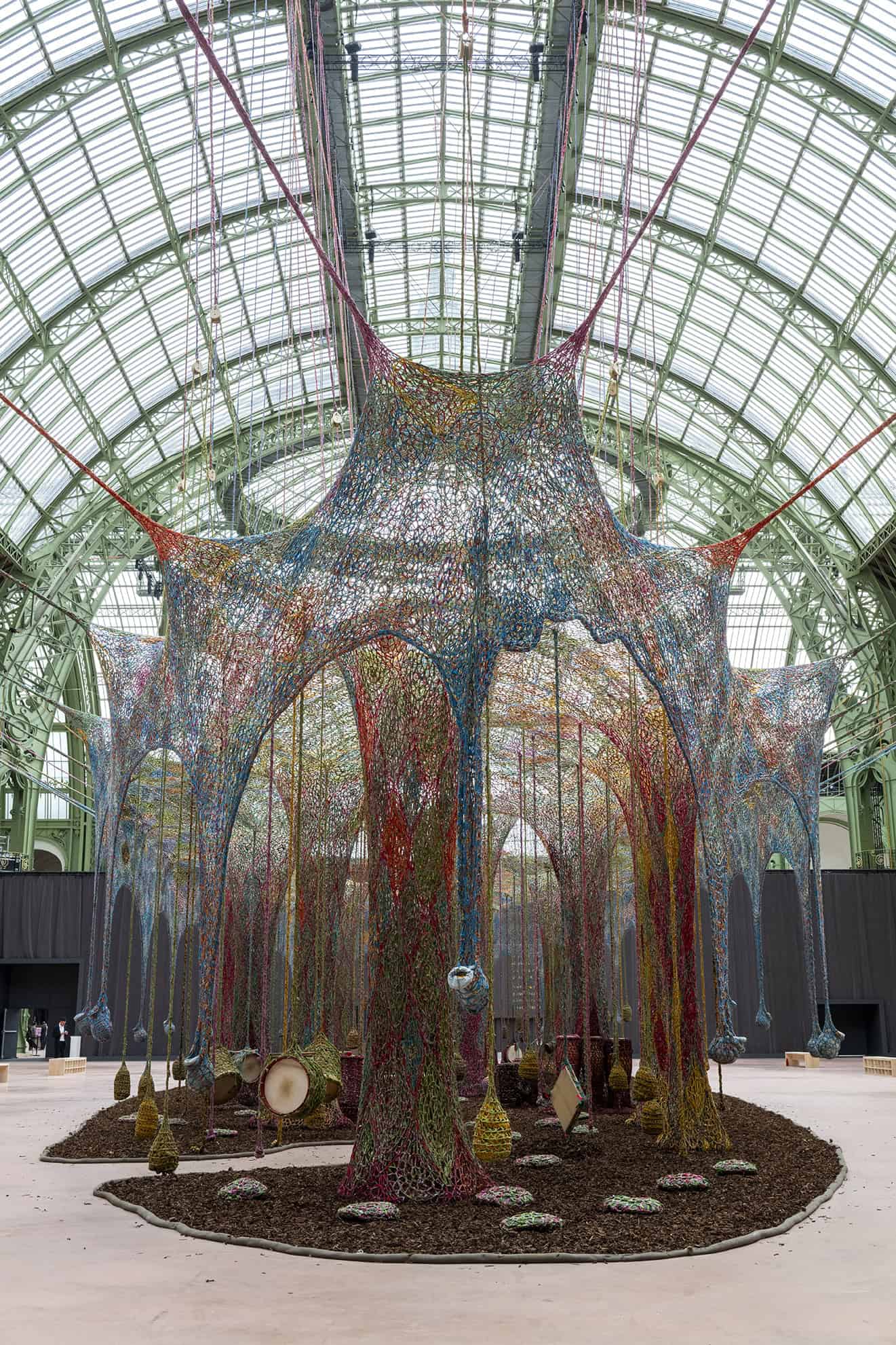 Wide view of Ernesto Neto’s Nosso Barco Tambor Terra, showing the full expanse of the woven canopy suspended inside the Grand Palais.