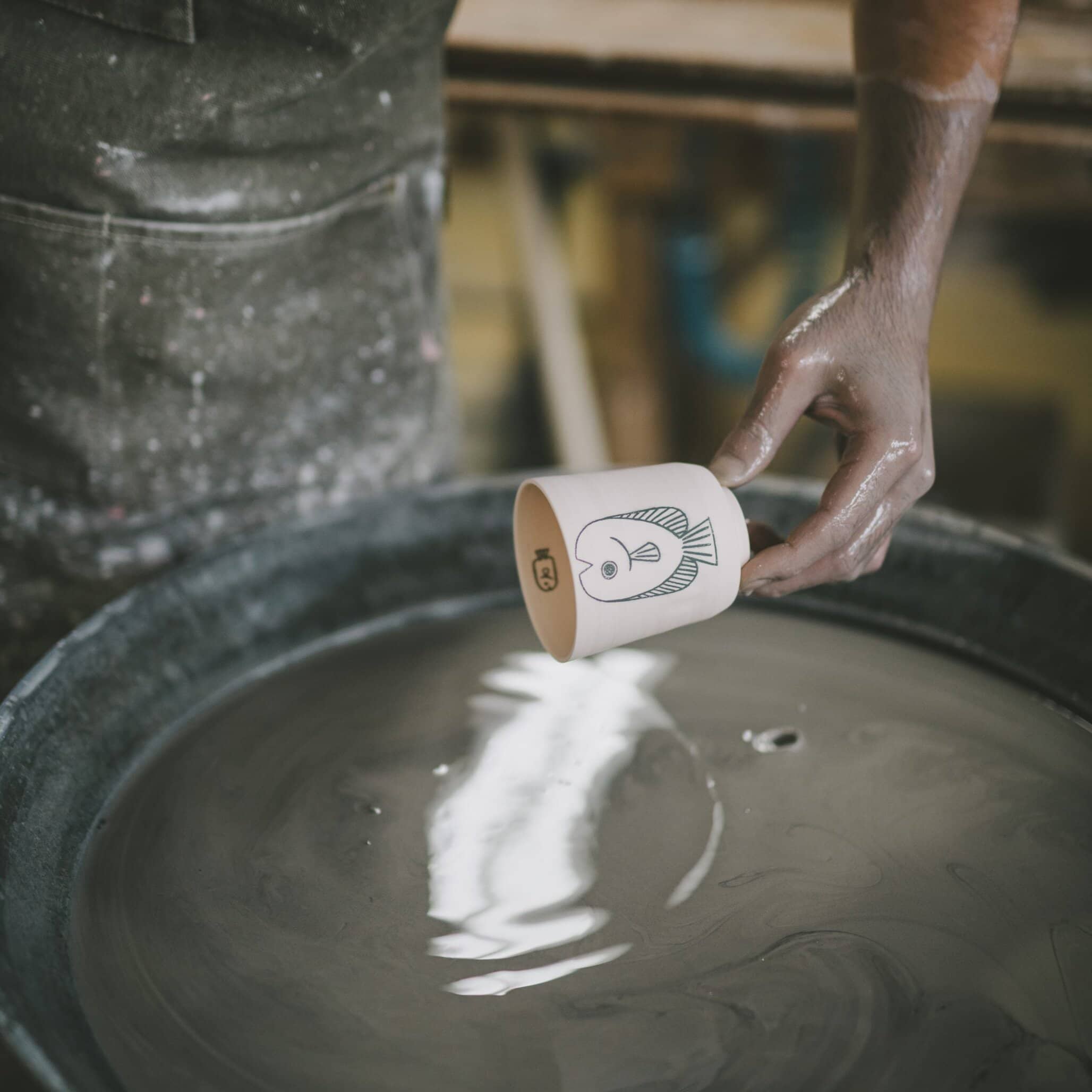 Cup illustrated by Amélie Fontaine dipped into slip during the traditional handmade production process in Japan.