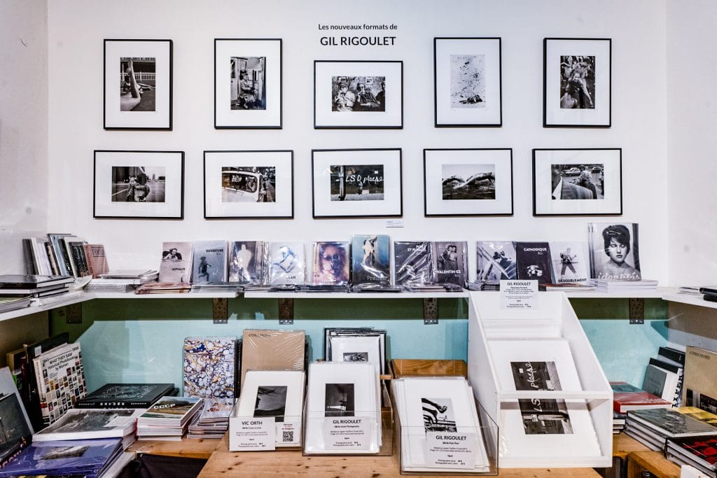 Inside Artazart Bookstore, with a shelf full of books and frames on the wall. Photograph by Louis Lambert 