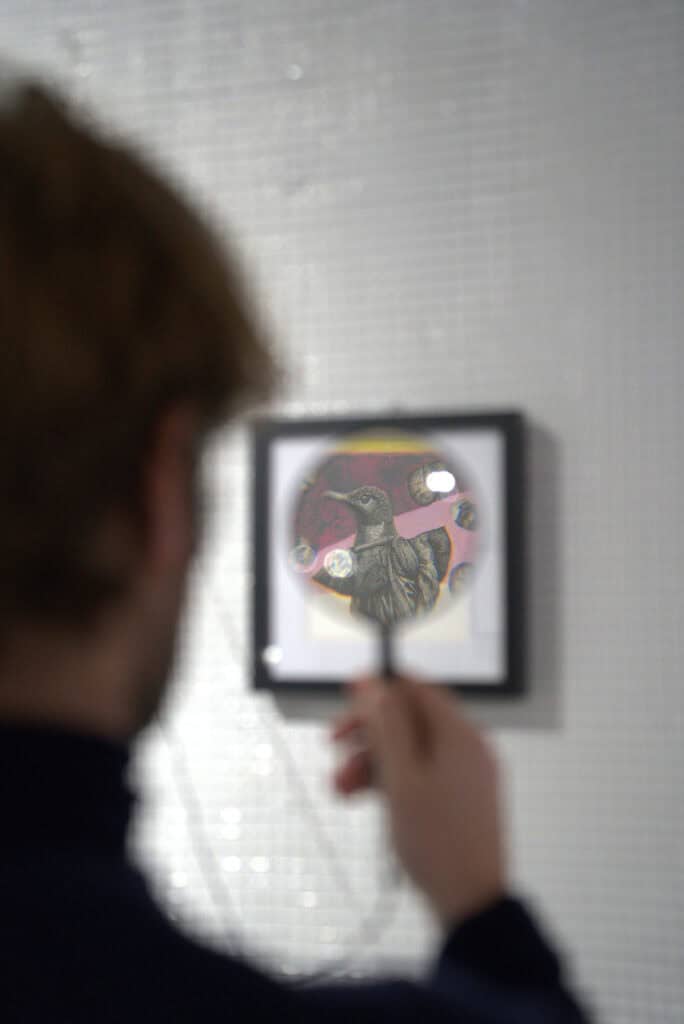 Up of an art piece featuring a bird with colorful elements, displayed at Arthur Yang's exhibition in.