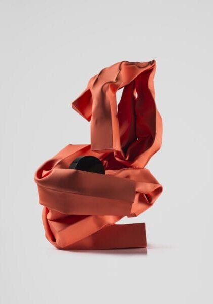 Abstract sculpture with red and black ribbons displayed at the Guggenheim Museum.