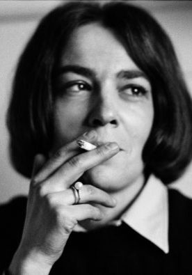 Black-and-white portrait of a Nicole Lala with a bob haircut, holding a cigarette near her lips and gazing thoughtfully to the side. Photo by Nicole Lala, courtesy of her daughter Delphine.