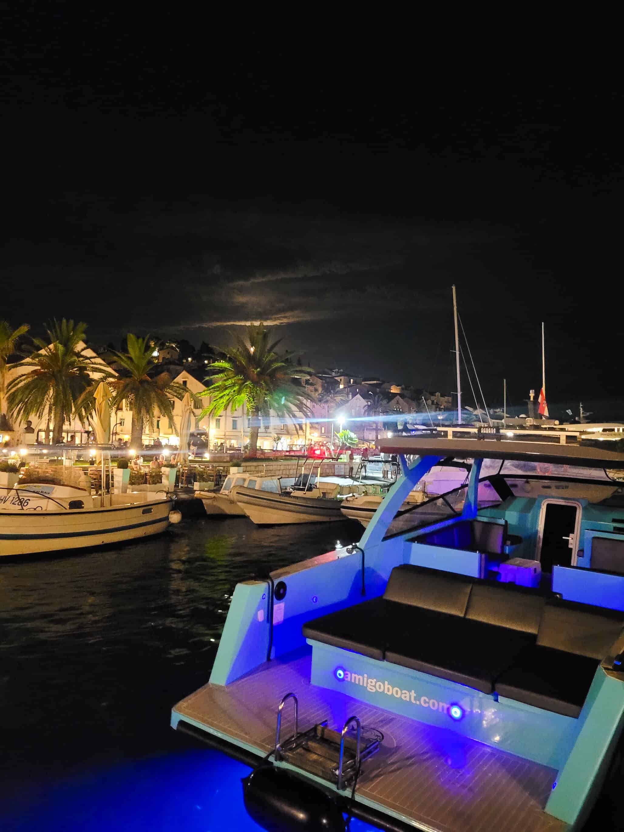color landscape photograph of boat in marina at night