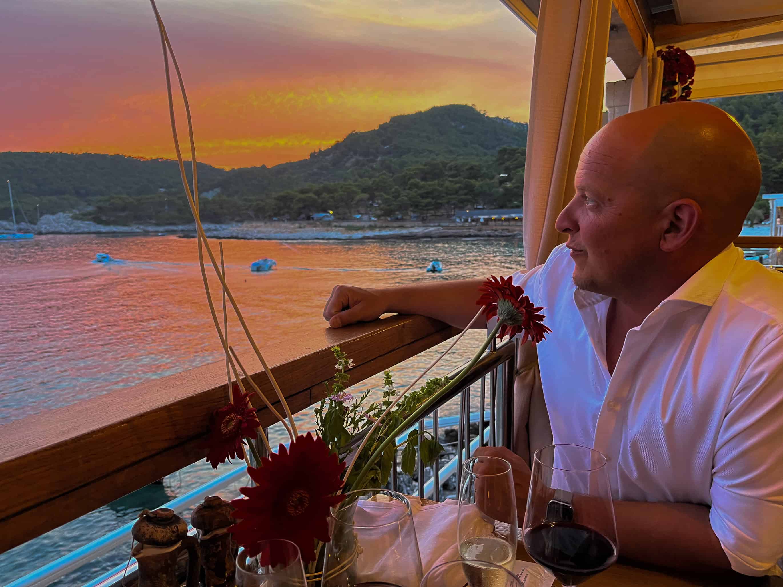 color portrait photograph of man overlooking sunset at sea