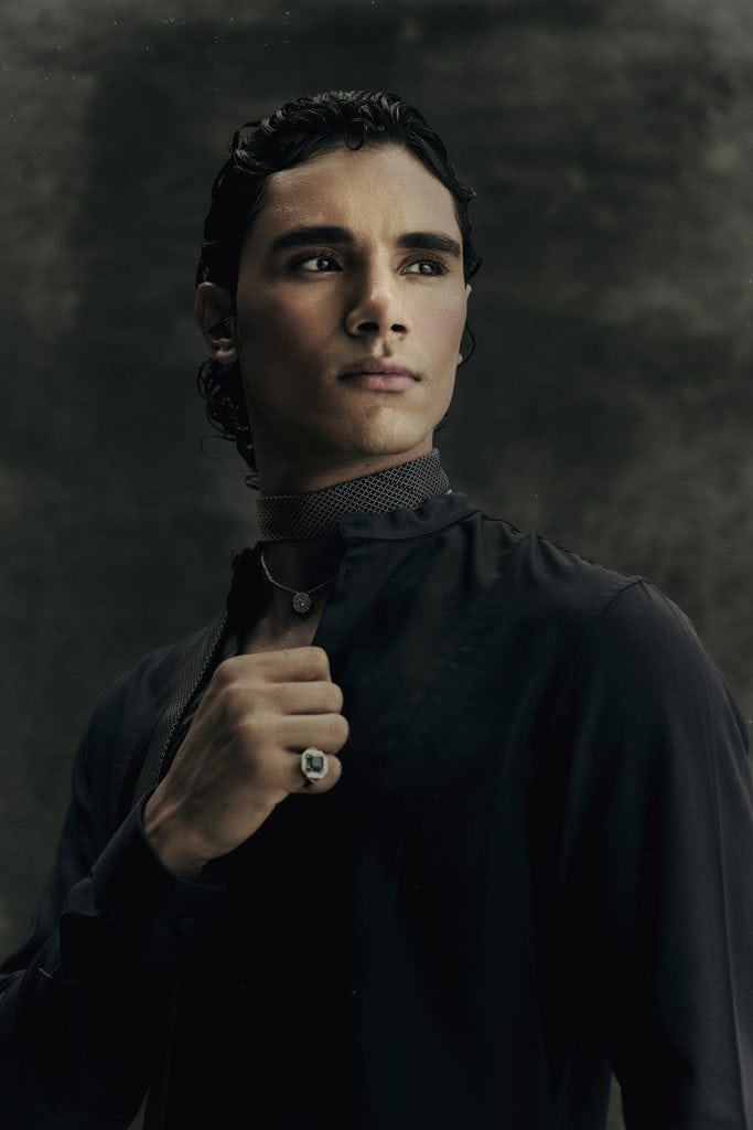 Kamal Sad close-up portrait in dark high-collar shirt, intense gaze, Eternal Allure photography by Ben Cope.