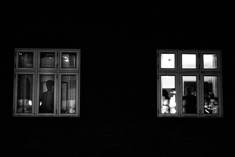 Photograph of two windows from outside at night by Tim Bertram