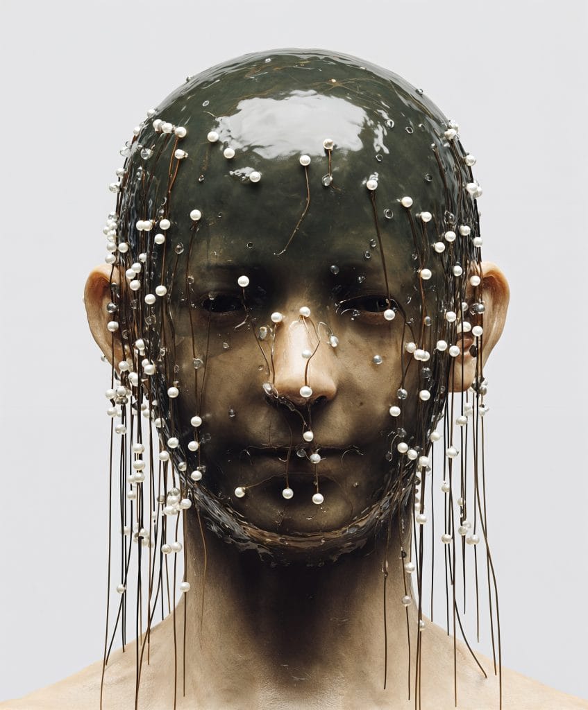 Lifelike synthetic bust in dark green with metallic piercings and suspended pearls, from Goo Vision’s digital archive